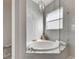 Soaking tub with glass enclosure and gray tile at 10511 Martinique Isle Dr, Tampa, FL 33647