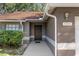 Inviting entryway with a dark brown front door and landscaping at 11315 N Ola Ave, Tampa, FL 33612