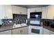 Well-equipped kitchen featuring white cabinets, granite countertops, and mosaic backsplash at 1515 Pinellas Bayway S # 35, Tierra Verde, FL 33715