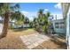 This backyard features a deck, a lush lawn, mature trees, and a concrete patio area at 3918 W Fig St, Tampa, FL 33609