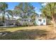 Spacious backyard featuring a wooden deck, lush greenery, and an open area for outdoor activities at 3918 W Fig St, Tampa, FL 33609