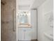 Accessible bathroom features a tile shower with grab bars, vanity, and updated lighting at 3918 W Fig St, Tampa, FL 33609