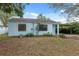 Quaint single-story home featuring light blue siding, white trim, and a covered carport at 3918 W Fig St, Tampa, FL 33609