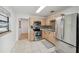 Updated kitchen featuring stainless steel appliances, light wood cabinets, decorative tile backsplash, and tile flooring at 3918 W Fig St, Tampa, FL 33609