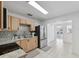 Bright kitchen featuring stainless steel appliances, light wood cabinets, granite countertops, and stylish backsplash at 3918 W Fig St, Tampa, FL 33609