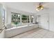 Bright sunroom featuring tile flooring, large windows with bench seating, and a ceiling fan at 3918 W Fig St, Tampa, FL 33609