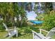 Relaxing backyard with a hammock, a view of the marsh, and white Adirondack chairs at 4021 Eagle Nest Dr, Hernando Beach, FL 34607