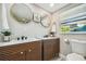 Bathroom with dual sinks, wood cabinets, and large mirrors at 4021 Eagle Nest Dr, Hernando Beach, FL 34607