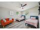 Guest bedroom with twin beds, an orange couch, and coastal decor at 4021 Eagle Nest Dr, Hernando Beach, FL 34607