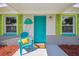 Welcoming front porch with teal chair and jellyfish decor at 4021 Eagle Nest Dr, Hernando Beach, FL 34607