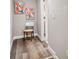 Small hallway with light grey walls, wood-look flooring, and modern art at 4021 Eagle Nest Dr, Hernando Beach, FL 34607