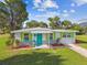 Charming one-story home with teal door and landscaping at 4021 Eagle Nest Dr, Hernando Beach, FL 34607