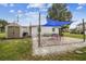 Outdoor patio area with a shade sail, seating, and a storage shed at 4021 Eagle Nest Dr, Hernando Beach, FL 34607