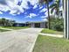 Single-story home with a large driveway, carport, and decorative screen, nestled amidst lush greenery at 560 Riviera Dr, Tampa, FL 33606