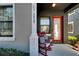 Front porch with red door and rocking chairs at 5829 Circa Fishhawk Blvd, Lithia, FL 33547