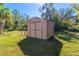 Tan colored storage shed in the backyard at 6847 Evans Way, Wesley Chapel, FL 33544