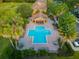 Aerial view of the community pool, surrounded by palm trees, landscaping, and lounging areas at 6922 Hawthorne Trace Ln, Riverview, FL 33578