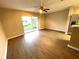 Living room features sleek floors, ceiling fan, and sliding glass doors to a serene backyard at 6922 Hawthorne Trace Ln, Riverview, FL 33578