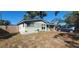 Updated home with teal door, landscaping, and car in driveway at 7045 Lenox Dr, New Port Richey, FL 34653