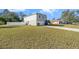 Gray house with white siding, attached garage, and a large grassy yard at 8388 Maltby Rd, Spring Hill, FL 34606