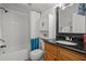 Bathroom with a shower/tub combo, wood vanity, and teal accents at 13608 S Village Dr # 6105, Tampa, FL 33618