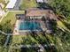 Aerial view of a screened-in pool surrounded by green grass and mature trees at 13608 S Village Dr # 6105, Tampa, FL 33618