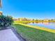 Lakefront backyard with lush grass and a brick walkway at 4845 Marble Springs Cir, Wimauma, FL 33598