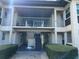Inviting condo exterior featuring a second story balcony, well-maintained landscaping, and covered entrances at 4854 Marine Parkway # 101, New Port Richey, FL 34652