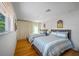 Bright bedroom with two twin beds, hardwood floors, and beachy decor at 747 Brightwaters Ne Blvd, St Petersburg, FL 33704