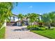 Home exterior showcasing a Mediterranean style with palm trees and a paved driveway at 747 Brightwaters Ne Blvd, St Petersburg, FL 33704