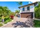 Two-car garage with decorative wooden doors and lush landscaping at 747 Brightwaters Ne Blvd, St Petersburg, FL 33704