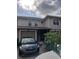 Front view of a two-story townhome with a black car parked in the driveway at 8003 Bally Money Rd, Tampa, FL 33610