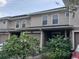 Tan two-story townhome with a two-car garage and landscaping at 8003 Bally Money Rd, Tampa, FL 33610