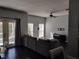 Relaxing living room with dark hardwood floors, gray sectional sofa, and large windows at 8003 Bally Money Rd, Tampa, FL 33610