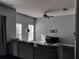 Living room with dark hardwood floors, gray sectional and ceiling fan at 8003 Bally Money Rd, Tampa, FL 33610