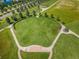 Aerial view of a neighborhood park with a large grassy field, walking paths, and mature trees at 8319 Swiss Chard Cir, Land O Lakes, FL 34637