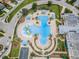 Aerial view of a community pool featuring a slide and lounge area with palm trees and umbrellas at 8319 Swiss Chard Cir, Land O Lakes, FL 34637