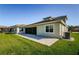 Back exterior view of the home with screen patio and well-maintained lawn at 8319 Swiss Chard Cir, Land O Lakes, FL 34637