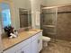 Modern bathroom with granite countertops, glass-enclosed shower, and ample storage at 8319 Swiss Chard Cir, Land O Lakes, FL 34637
