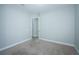 A clean, carpeted bedroom with a doorway leading to an unseen room at 8319 Swiss Chard Cir, Land O Lakes, FL 34637