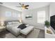 Staged bedroom with bed, bench, ceiling fan, and natural light from the windows at 8319 Swiss Chard Cir, Land O Lakes, FL 34637