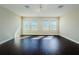 Spacious room with wood flooring and several windows, perfect for multipurpose use at 8319 Swiss Chard Cir, Land O Lakes, FL 34637