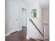Upstairs hallway with hardwood floors and doors leading to different rooms at 8319 Swiss Chard Cir, Land O Lakes, FL 34637