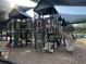 Community playground with climbing structures, slide, and shaded seating areas, ideal for Gathering fun at 8319 Swiss Chard Cir, Land O Lakes, FL 34637