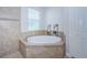Corner soaking tub with decorative tile surround, perfect for relaxation at 8319 Swiss Chard Cir, Land O Lakes, FL 34637