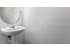 Powder room featuring pedestal sink and a round mirror at 10817 Great Carlisle Ct, Riverview, FL 33578
