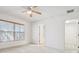 Bright bedroom features carpeted floors, a ceiling fan, and a sunlit window with wooden blinds at 10817 Great Carlisle Ct, Riverview, FL 33578