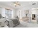 Bright bedroom with light walls, a ceiling fan, and a large window at 10817 Great Carlisle Ct, Riverview, FL 33578