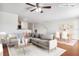 Virtually staged living room with L-shaped sofa, dining area, and hardwood floors at 10817 Great Carlisle Ct, Riverview, FL 33578