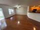 Hardwood living room area with view of the kitchen and sliding glass doors to the patio at 10817 Great Carlisle Ct, Riverview, FL 33578